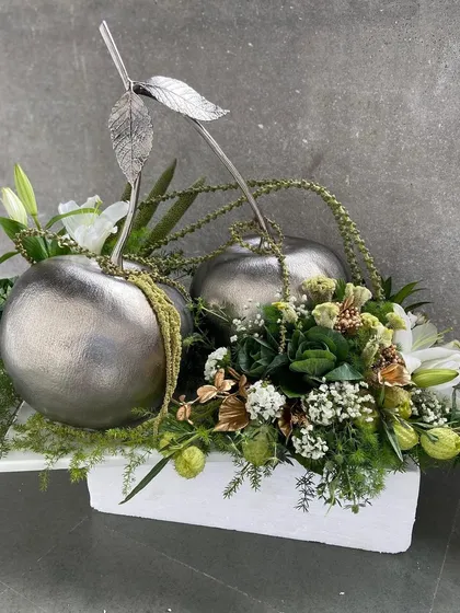 For a gift that makes a bold artistic statement, we created this arrangement featuring sculptural silver apples nestled in fresh florals. It is a unique centerpiece, perfect for corporate or milestone gifting.