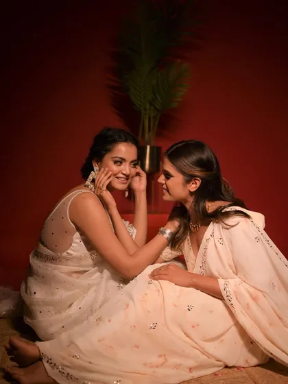 A shot capturing a shared secret. The styling here is about creating a narrative, using fashion to tell a story of friendship and elegance.