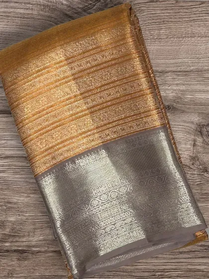A Kanchi silk saree with a gold striped body and a silver brocade border.