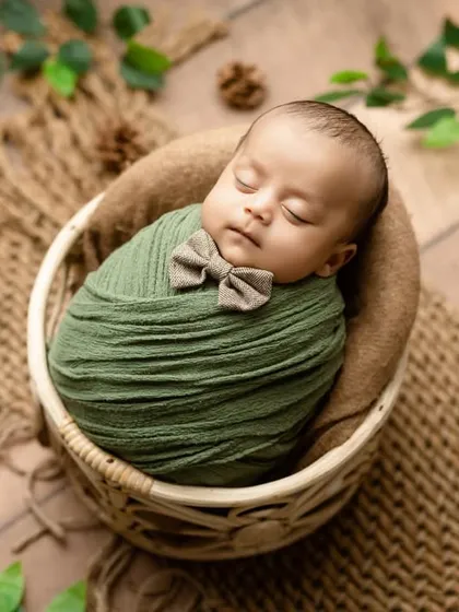 A full view of the little gentleman setup, with a rustic basket and natural elements.