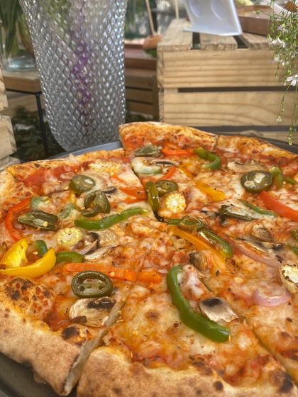 A freshly baked vegetarian pizza, loaded with colorful bell peppers, mushrooms, and spicy jalapeños. This image showcases the vibrant and delicious options we offer for all dietary preferences.