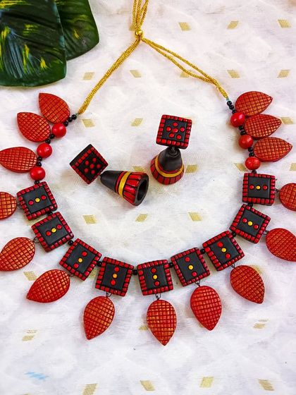 A bold red and black version of the square and leaf necklace. The colors are powerful and traditional, while the design is modern and geometric.