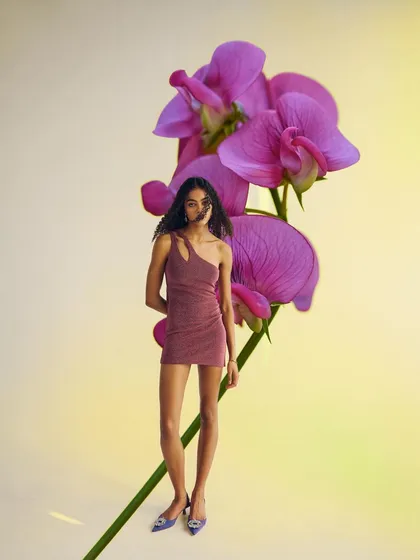 A conceptual and surreal portrait for a model's portfolio, where the model appears as a part of a giant purple flower.