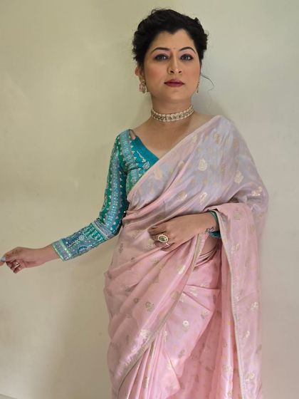 An elegant look for Savaniee Ravindrra. She is wearing a beautiful light pink saree with a contrasting embroidered turquoise blouse, paired with a soft, braided updo.