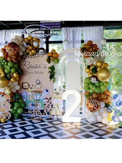 Raisa's 'Two Wild' birthday was a fun and stylish jungle-themed event. We used animal print balloons, cute character props, and a light-up number '2' against a modern black and white checkered floor.