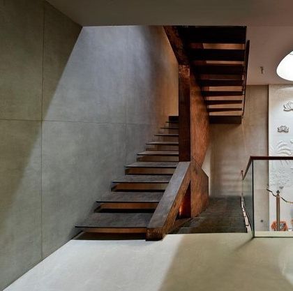 The staircase at Sainik Farms is positioned next to the family temple, which is lit by a circular skylight. The light washes over a carved stone frieze, making this transitional space a focal point of beauty and spirituality.
