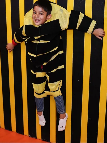 Get ready for unique and interactive fun. Here, a child enjoys our sticky velcro wall, one of the many fun activities available that you won't find anywhere else.