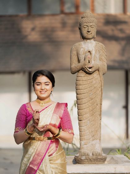 A serene moment for the bride. Her makeup is classic and understated, allowing her natural beauty and the elegance of her saree to take center stage.
