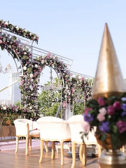 A detail shot of the floral archways and traditional brass decor elements at Reeya and Parth's rooftop wedding. The combination of modern structure and classic details created a balanced and beautiful design.