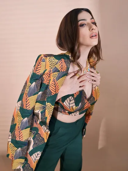 An artistic pose that shows off the cool, leafy print of the outfit. The makeup is kept warm and neutral to complement the colors in the jacket.