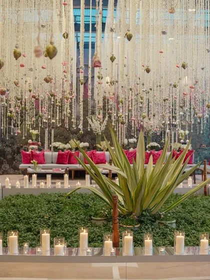 A central green space surrounded by hundreds of pillar candles, leading to the main event area. We use lighting and landscape design to guide guests through the venue and build anticipation.