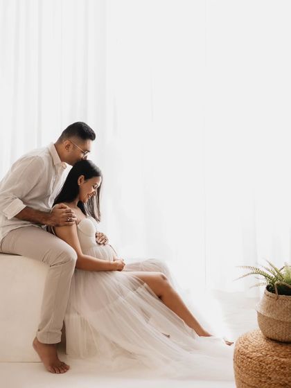 A soft and dreamy portrait. The partner’s gentle kiss on her forehead and the light pouring in from the window create a truly romantic feel. Her white tulle gown adds to the ethereal quality of the shot.
