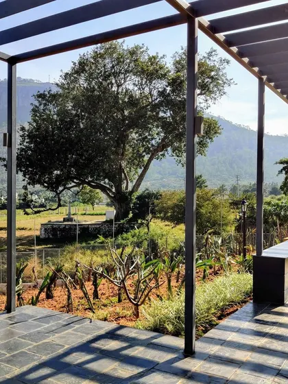 A shaded pergola walkway offers a cool respite and frames the stunning view of the landscape beyond. This structure adds an architectural element to the garden while providing a comfortable transition between different outdoor areas.