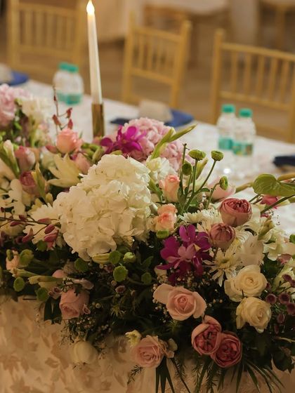 A close-up of the floral runner on the head table. A mix of hydrangeas, roses, and orchids in soft pastel shades created a lush, textured centerpiece that was both classic and stunning.