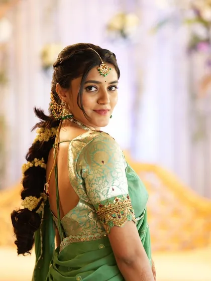 I believe in elegance that feels effortless. This look for a special event features soft, glowing makeup that enhances natural beauty, paired with a beautifully braided hairstyle and a pastel green saree. It's a perfect example of sophisticated party makeup.