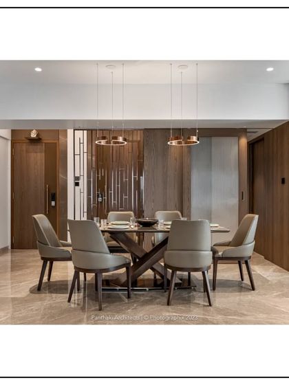 A closer look at a dining space where every detail is considered. The sleek dining table is complemented by comfortable chairs and striking copper-toned pendant lights, creating a sophisticated setting for any meal.