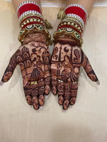 A classic Karwa Chauth design that tells a story across both hands. One hand shows a woman looking at the moon through a sieve, and the other features her partner, set against a backdrop of traditional architecture.
