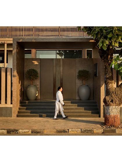 A person walks past the new grand entrance, highlighting the scale and impact of our architectural intervention on the public-facing side of the venue.
