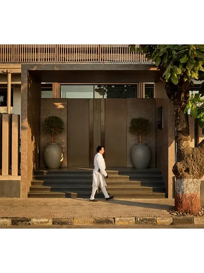 A person walks past the new grand entrance, highlighting the scale and impact of our architectural intervention on the public-facing side of the venue.
