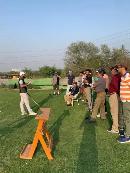 A group of engaged golfers listens intently during a Driver Masterclass. These sessions provide direct access to expert knowledge and personalized tips.