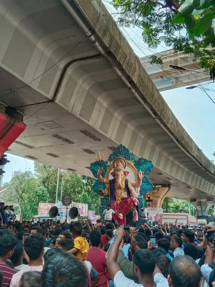 The energy of an idol procession is unmatched. Here you can see the Kamathipura cha Mahaganpati, one of my large-scale creations, making its way through the streets of Mumbai, a testament to the city's grand Ganeshotsav spirit.