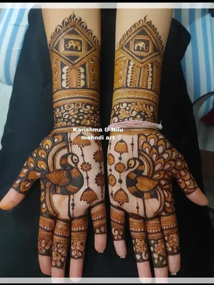 Here, I've combined figurative art with architectural details. The design features peacocks, hanging jhumkas, and jharokhas containing elephants, showcasing how to build a narrative within a bridal mehendi layout.