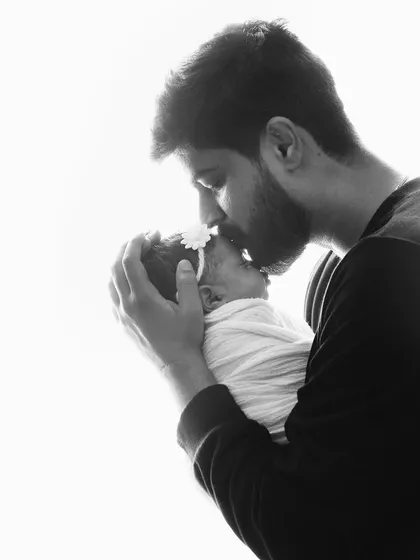 The quiet, tender moments are often the most powerful. A father's gentle kiss on his newborn's head speaks volumes, capturing a bond that is deep, protective, and full of love from the very first day.