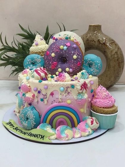 A different view of the vibrant and playful candyland cake. This eggless creation is loaded with homemade treats, making it a fun and delicious centerpiece for a child's birthday party.