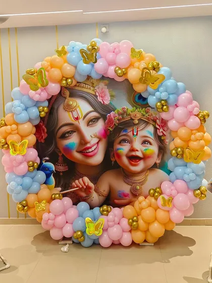 This Krishna-themed baby shower was a divine celebration. I created a circular backdrop featuring a beautiful illustration of Yashoda and Krishna, framed by a vibrant garland of pastel pink, blue, and orange balloons with golden butterfly accents. It was a unique and blessed event for the mom-to-be.
