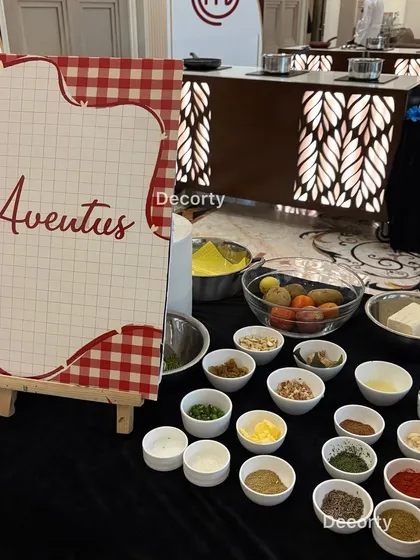 Each team gets a fully prepped station with a variety of fresh ingredients and spices. This image shows the 'Aventus' team's table, laid out with everything they need for the culinary challenge.