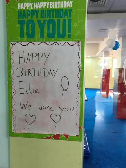 "Happy Birthday Ellie, We love you!" A sweet, handwritten note from the party guests, showing the love and friendship shared during the celebration.