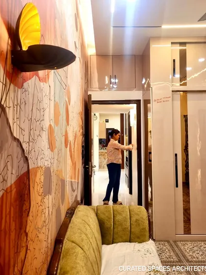 This shot highlights the custom wallpaper and unique wall lamp that add a personal and artistic touch to this beautifully designed closet room.
