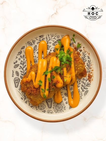 This dish features soft, pan-fried cottage cheese seasoned with a crunchy, aromatic dukkah spice blend from the Middle East. It is served with a creamy sauce and fresh herbs for a complex and satisfying flavor.