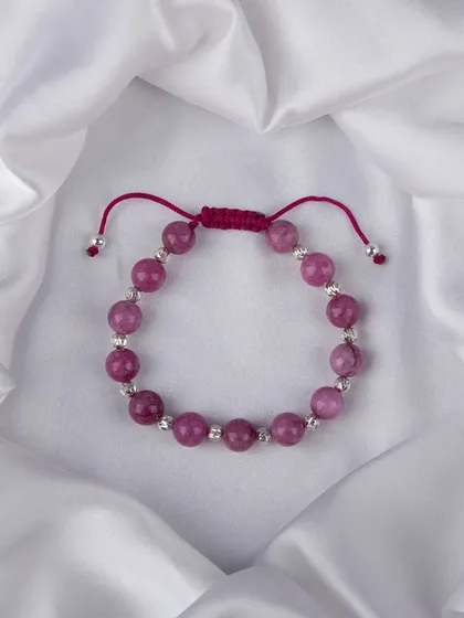 A beaded bracelet with vibrant pink stones and silver accents.