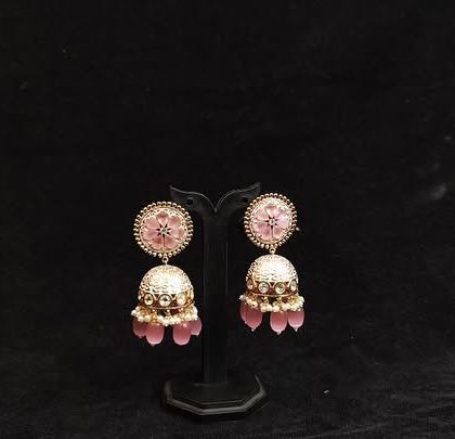 A pair of delicate jhumkas with pink enamel and beads, perfect for a feminine and graceful look.