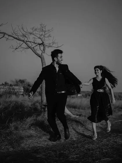 Running hand in hand through the field. This black and white shot is full of movement and freedom, capturing the excitement and joy of starting a new life together.