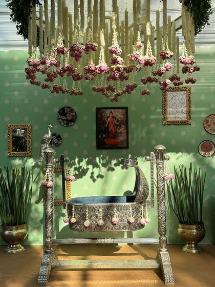 Sunlight streams in, casting beautiful shadows from the hanging floral chandelier over the silver cradle.