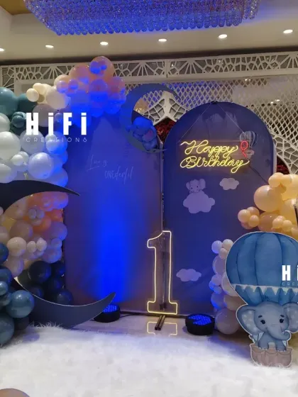 A dreamy "over the moon" themed first birthday with a beautiful blue and white color scheme, moon prop, and hot air balloon element.