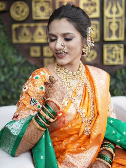 A stunning bridal portrait, capturing the bride's gentle smile and the rich details of her saree and jewelry.