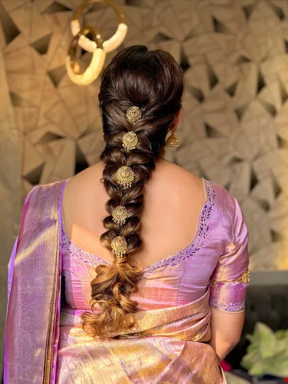 The traditional South Indian bridal hairstyle is an art form. This is a beautifully executed braid, adorned with classic gold "jadanagam" hair ornaments.