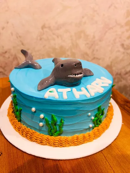 A thrilling shark cake with a 3D shark emerging from the blue water, perfect for an ocean-themed party.