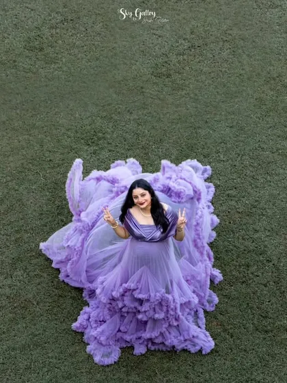 A fun and happy shot from above. The mom-to-be flashes peace signs, looking joyful and relaxed in the stunning lavender gown. My goal is to make you feel comfortable and have fun.