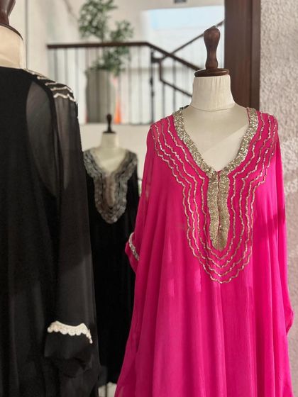 A closer look at the fuchsia kaftan, highlighting the delicate gold and silver embroidery that elevates the simple silhouette.