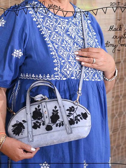 A close-up of the Black Lace Crystal Tiny Mandy, highlighting the detailed black floral embroidery.