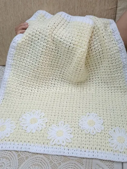 This soft baby blanket is made in a lovely pale yellow with a clean white border and is adorned with five delicate white daisy flowers.