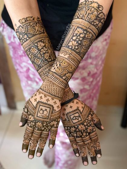 A crossed-hands pose showing the complete, symmetrical engagement design with ring and heart motifs.