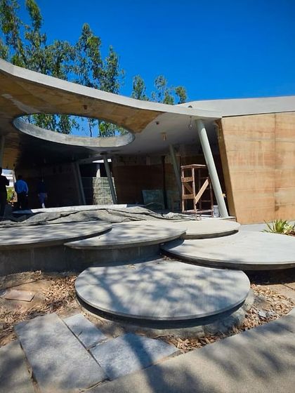 A canvas where architecture bends and flows. This image shows the interplay of curved concrete forms, circular platforms, and an oculus in the roof, all designed to harmonize with the natural environment.