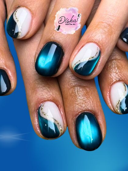 Ocean waves meet cat eye magic. This stunning design combines a deep teal cat eye polish with a crisp white base and a delicate gold glitter line.