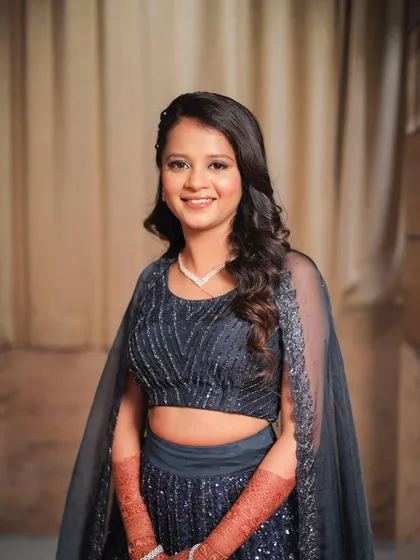 A full-length view of this sparkling navy blue lehenga. The makeup is kept clean and radiant to balance the intricate details of the outfit.