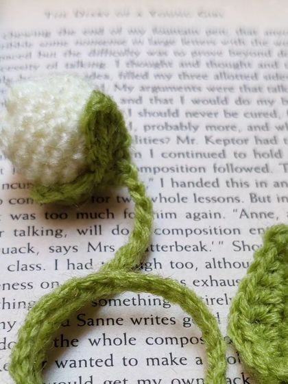 A white tulip bookmark inside a book.